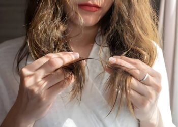 Asian woman holding her damaged split ended and messy hair
