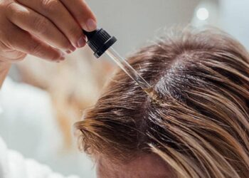 Woman applies oil to her hair with pipette. Beauty caring for scalp and hair
