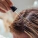 Woman applies oil to her hair with pipette. Beauty caring for scalp and hair