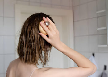 Woman makes a head self massage for hair growth