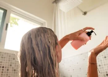 Woman takes shower and uses shampoo