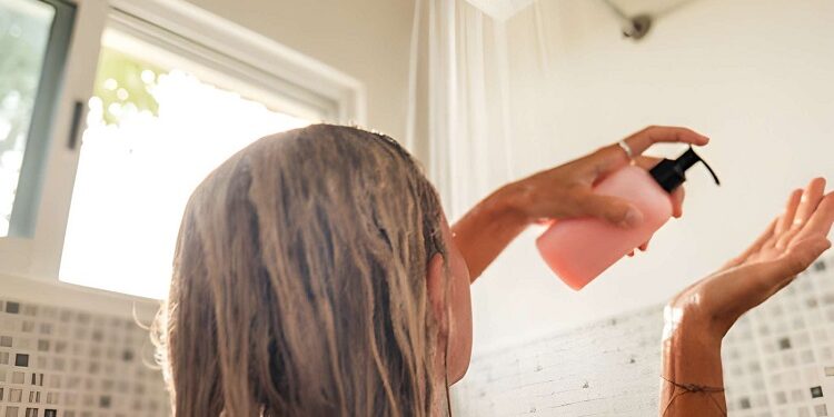 Woman takes shower and uses shampoo