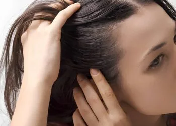 Young worried woman checking her hair and scalp