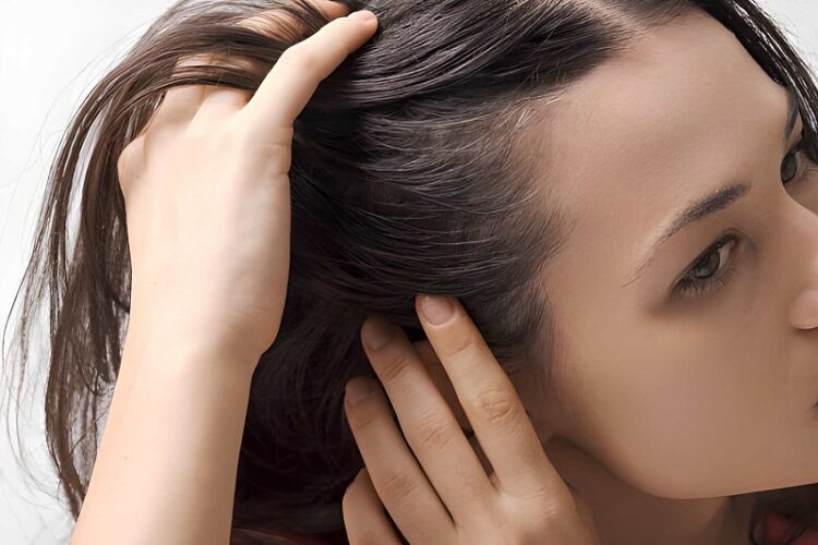 Young worried woman checking her hair and scalp