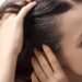 Young worried woman checking her hair and scalp