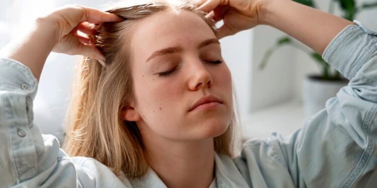 woman giving herself scalp massage
