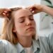 woman giving herself scalp massage