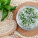 Homemade mint exfoliating scrub (scalp peeling, bath salt) with sugar, chopped mint leaves, olive oil and essential mint oil. Natural skin and hair care